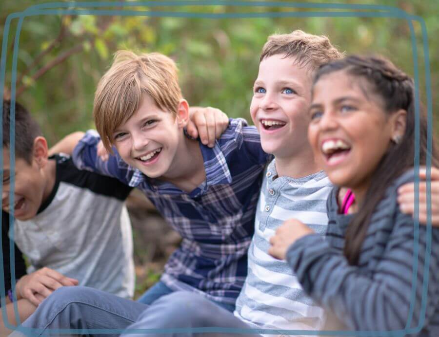 Group of 4 middle school students laughing outdoors in the Cleburne homeschool coop