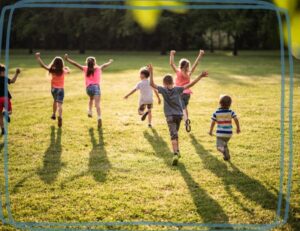 A group of elementary children running on a sunny field