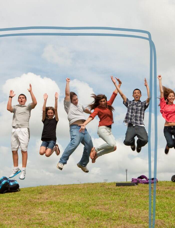 Group of teens jumping in field