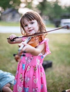 Preschool student in pink dress with violin